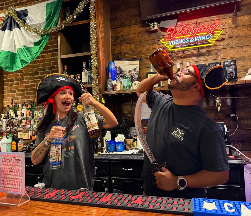 Bartenders in pirate hats behind the bar